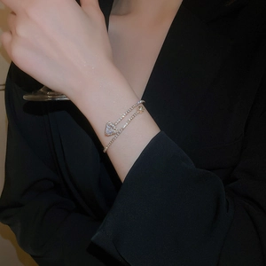 Macro detail of silver bangle featuring square-cut zircon and paved crystal chain links