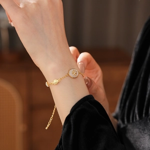 Detail of adjustable gold star pendant bracelet with zircon on woman's wrist
