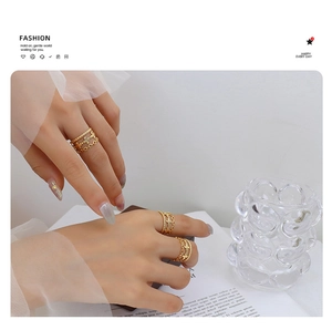 Detalle de anillos geométricos bañados en oro con diseños de flores y eslabones