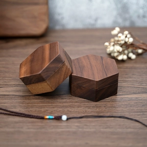 Macro shot of two hexagonal black walnut wood jewelry boxes with clear natural grain texture