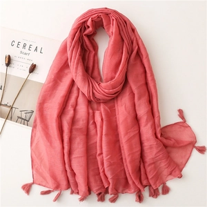 Detail of coral pink cotton scarf with glitter metallic yarn and elegant fringe trim