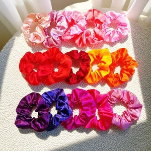 Detailed set of 15 colorful satin scrunchies in pink, red, orange, and purple hues