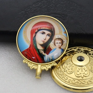 Macro shot of gold religious icon with Virgin Mary and Child on a carved metal base
