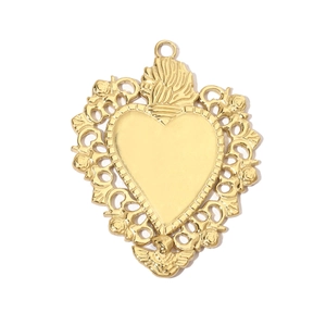 Macro detail of golden baroque sacred heart pendant with angel carving and sun rays