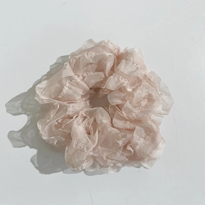 Detailed view of the pink beige organza scrunchie with soft ruffled lace texture