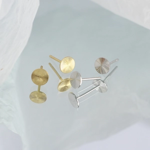 Macro view of gold and silver S925 sterling silver stud earrings with radial texture