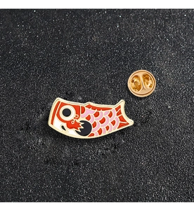 Detailed macro view of a red and pink enamel koi fish pin with a gold butterfly clutch