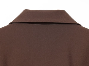 Détail du col à revers marron et de la texture tissée d'une robe à manches longues
