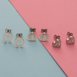 Detail of silver stainless steel crescent moon shell and heart stud earrings set