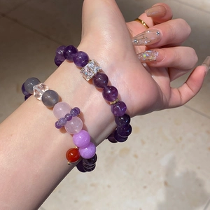 Close-up of beaded bracelets with purple amethyst and multicolor agate beads on wrist