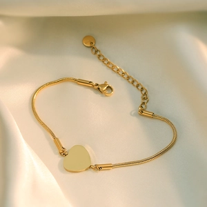 Elegant 18K gold plated heart pendant bracelet with snake chain on cream silk fabric