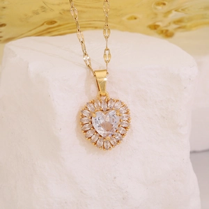 Dettaglio del ciondolo a cuore con zircone e alone a sole su catena in acciaio oro