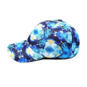 Side view of tie-dye baseball cap with blue marble pattern and golden line accents