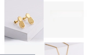 Detailed view of gold plated pineapple stud earrings with intricate mesh pattern and chain