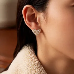 18k gold plated heart earrings with checkered zircon inlay for women shown on model