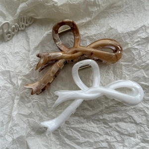 Detail of marble pattern resin hair claws in brown and white bow-shaped designs
