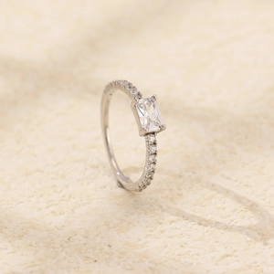 Macro view of silver wedding ring with square-cut center stone and pave diamond band