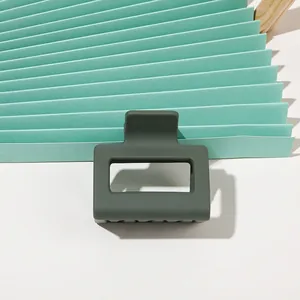 Macro detail of dark green matte shark hair clip with rectangular cutout design