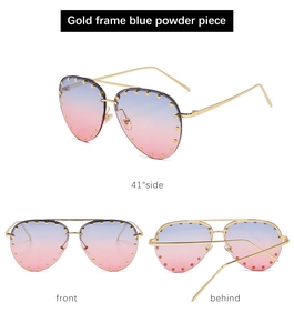 Detail view of gold frame sunglasses with blue-pink gradient lenses and rivet accents