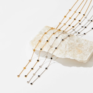 Y-shaped zircon tassel necklace in gold and silver finish with elegant black dot accents