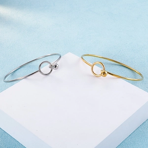 Detail view of minimalist gold and silver round metal bangles with bead accents