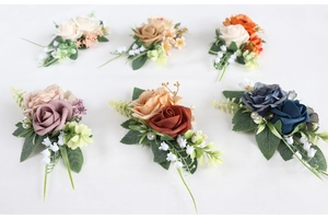 Detailed flat lay of artificial rose corsages with silk petals and pearl accents