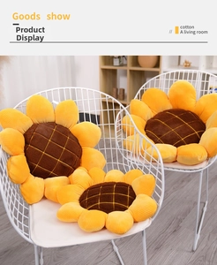 Sunflower plush floor cushion on white metal chair in a cozy minimalist room setting