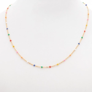 Detail view of a gold beaded necklace with colorful enamel charms on a white jewelry display
