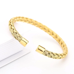 Golden braided mesh open bangle bracelet made of stainless steel on white background