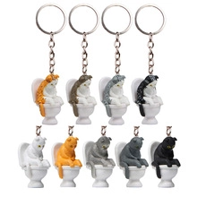 Set of eight cartoon cat keychains sitting on mini toilets in assorted colors