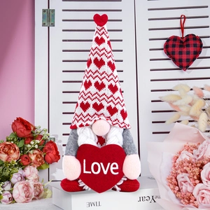 Macro detail of Valentine's gnome with knitted hat and heart holding a Love sign