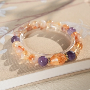 Macro detail of bead bracelet featuring amethyst, citrine beads and a faceted orange gem