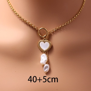 Layered stainless steel necklace with gold heart pendant and baroque pearls on a model