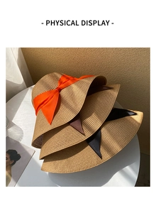 Close-up of three woven straw sun hats with orange, brown and black ribbon bows