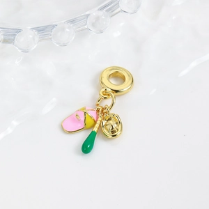 Macro shot of gold baseball charm with colorful enamel hat, bat, and glove details