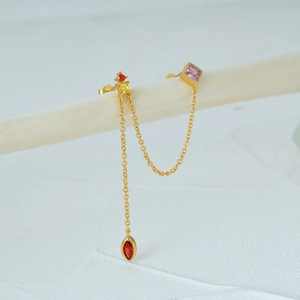 Detail showing gold tassel chain earring with pink square gem and S925 hallmark