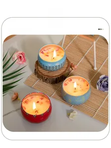 Detailed top view of tin scented candles with dried rose petals on a rustic wood background