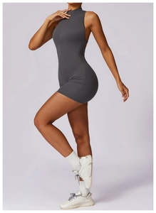 Detail of grey athletic bodysuit featuring high neck zipper and seamless yoga fabric