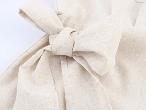 Détail d'un grand nœud sur une robe en lin kaki montrant la texture du tissu
