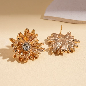 Detailed close-up of golden sunflower stud earrings with a sparkling zircon center