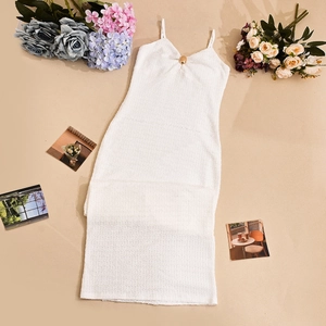 Détail d'une robe en tweed blanc texturé 3D avec boucle dorée élégante au décolleté