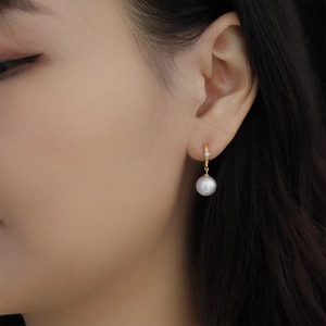 Close-up of elegant S925 silver pearl earring with zircon inlay on a female model