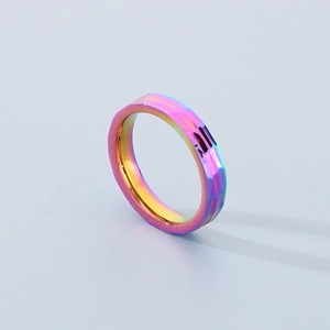 Macro detail of a rainbow titanium steel ring with a faceted surface and polished finish