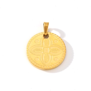 Macro detail of 18K gold-plated clover pendant with intricate dotted edge on white background