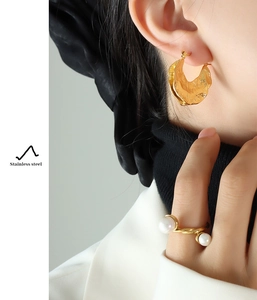 French style gold hammered stainless steel earrings and pearl ring worn by model
