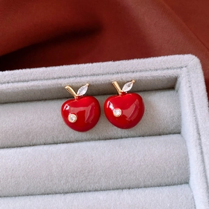 Macro view of cherry-shaped earrings with red enamel and sparkling cubic zirconia stones
