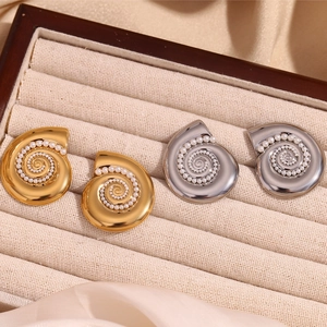 Detailed macro of 18K gold and silver plated conch earrings with embedded pearls