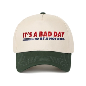 Detail of embroidered 'IT'S A BAD DAY TO BE A HOT DOG' text on two-tone baseball cap