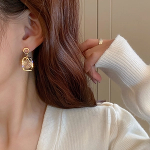 Elegant gold square geometric drop earrings with clear crystal stones on model
