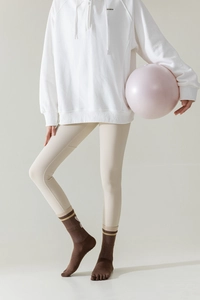 Brown striped five-finger yoga socks shown on model with beige leggings and a pink ball